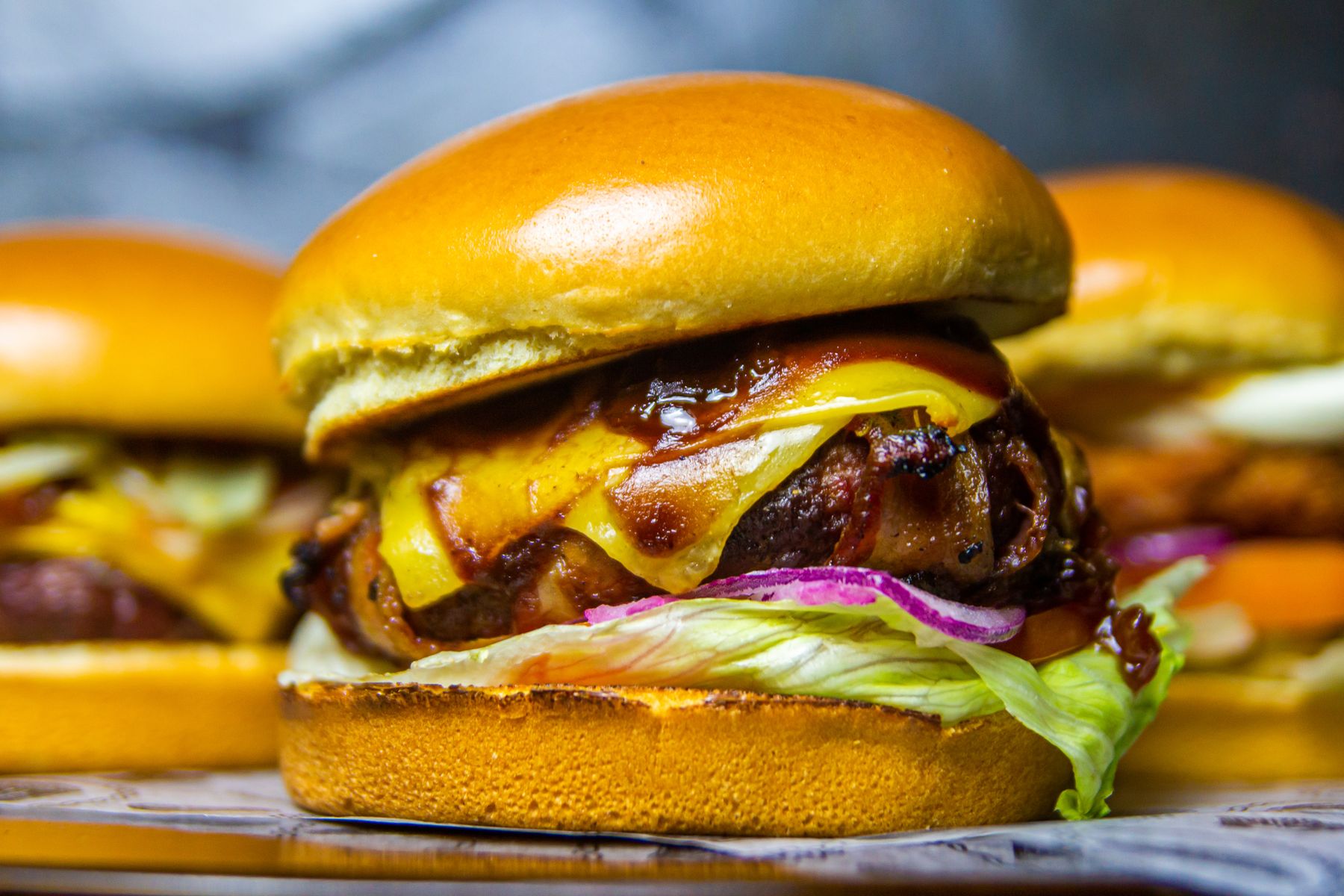 Stacked cheeseburgers with melted cheddar and barbecue sauce